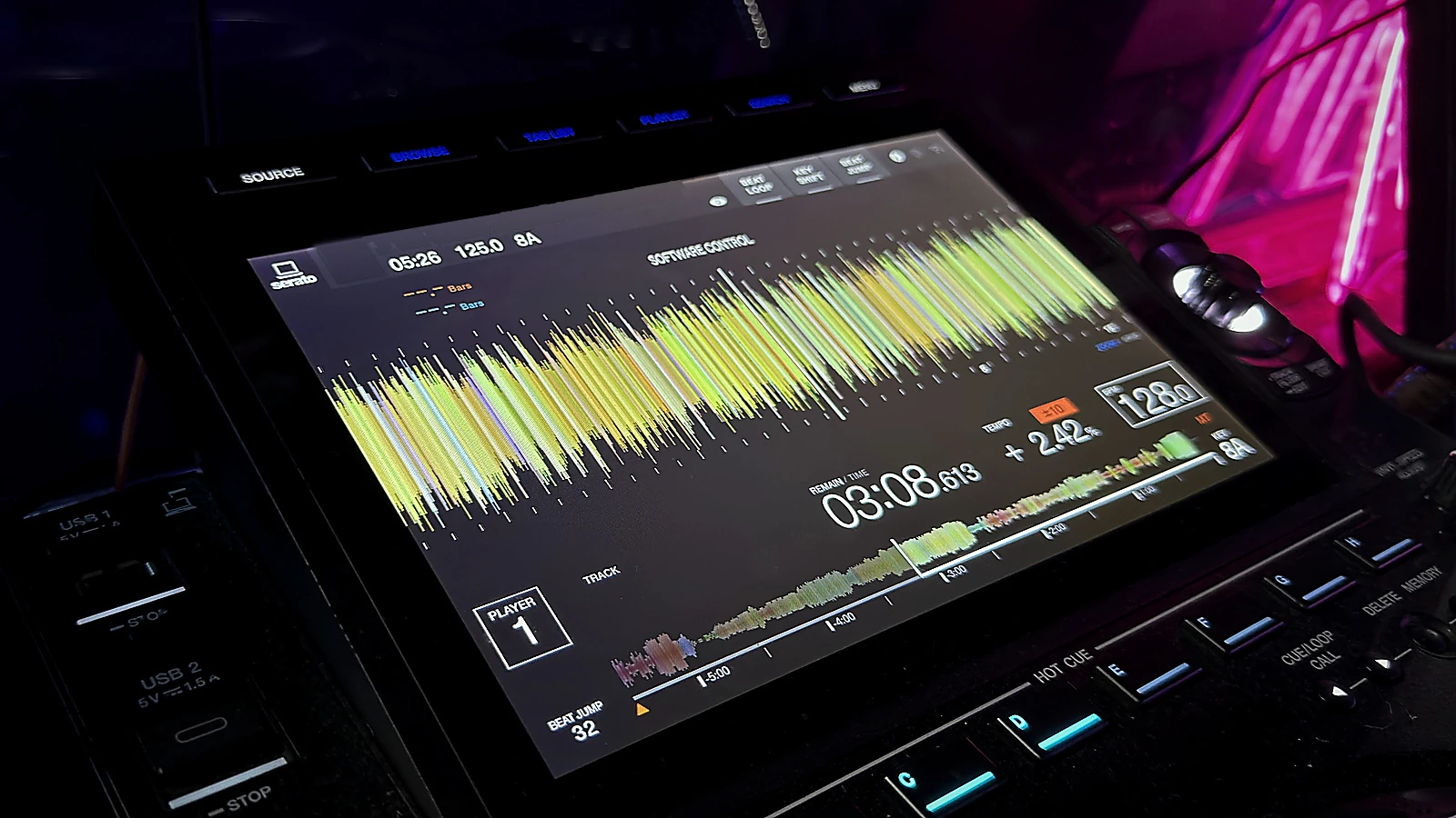 CDJ player in a live performance booth with waveform and timing information visible.